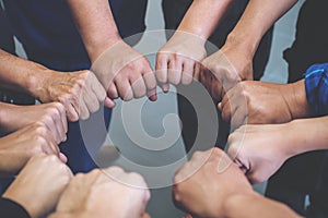 Many people hands holding a jigsaw puzzle in circle together