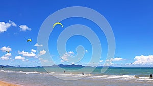 Many people or tourist playing kite surfing on sea with clear blue sky and cloud background and copy space at tropical beach