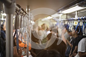 Many people are traveling by electric train during rush hour.This image is soft Focus