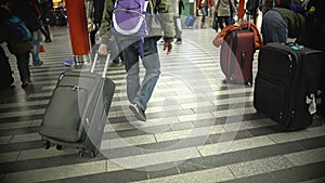 Many people walking with luggage, busy passengers at airport or