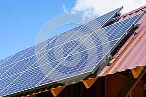 Many photovoltaic solar panels mounted on wooden house roof, roof of solar cells