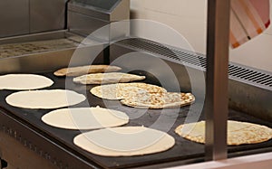 Many piadine on the hot plate of a restaurant in Italy