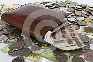 Many Pile of coins baht Thailand currency in yellow ceramic bowl.