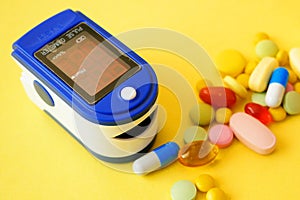 many pills, stethoscope, pulse oximeter for finger tip simultaneous monitoring of blood flow and transcutaneous oxygen on table