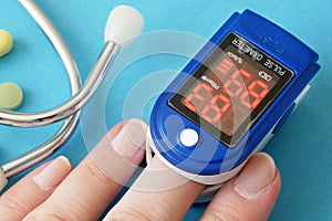 many pills, stethoscope, pulse oximeter for finger tip simultaneous monitoring of blood flow and transcutaneous oxygen on table