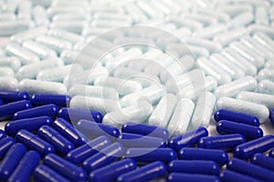 Many pills and tablets in blue and white color. Pharmacy medical background. Close up of a lot of drugs