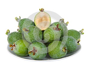 Many pineapple guava stacked on a plate isolated on white