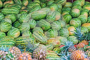 Many pineapples and water melons on the ground in food market in Zanzibar, Tanzania