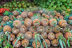 Many pineapples and water melons on the ground in food market in Zanzibar, Tanzania