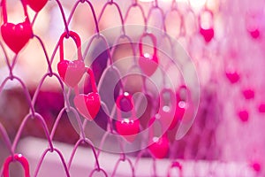 Many pink hearts hanging on a metal cage,Valentine`s concept.Soft focus