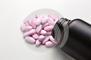 Many pink tablets pills with bottle