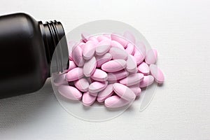 Many pink tablets pills with bottle