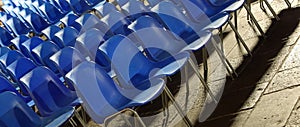 empty blue plastic chairs without people before the start of a live concert