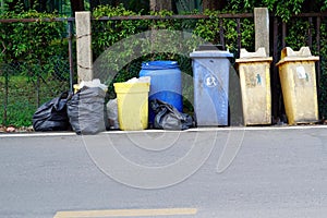 A many plastic garbage bags can with a black pile bags on beside the road wait for a garbage collector