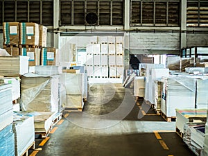 Many plastic packaging of paper in a large warehouse.