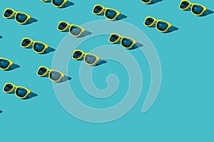 Many plastic sunglasses pattern on turquoise blue background with copy space