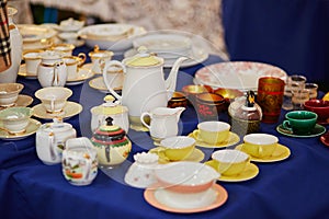 Many porcelain tea cups and pitcher on flea market in Paris