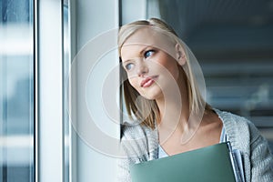 So many possibilities after college. A thoughtful young college student gazing out a window.