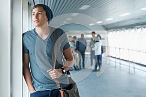 So many possibilities..Sho tof a young male college student lookigng through a window thoughtfully.