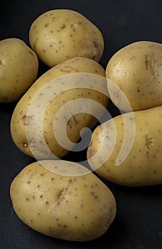 Many potatoes on a black background Stacked image Dark food photography