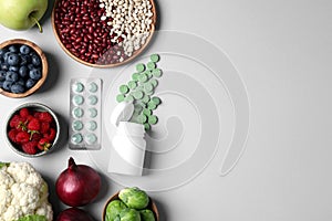 Many prebiotic pills and food on grey background, flat lay. Space for text