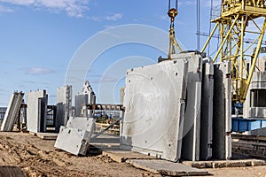Many precast concrete wall panels are stocking in the storage area waiting for installation at construction site