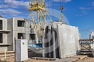 Many precast concrete wall panels are stocking in the storage area waiting for installation at construction site