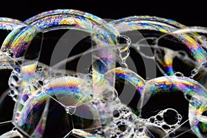 Many rainbow bubbles on a black background. Abstract detail