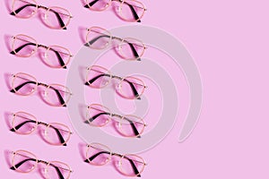 Many reading glasses on pink background pattern