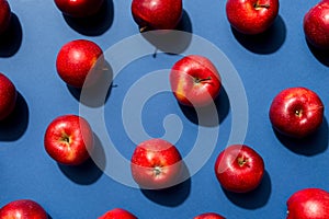 Many red apples on colored background, top view. Autumn pattern with fresh apple above view