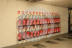 many red Fire Extinguishers at a wall