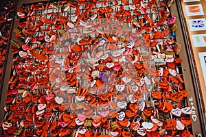 Many red locks in the form of hearts with the names of lovers. Near Juliet`s house in Verona. Love, hearts lock Italy
