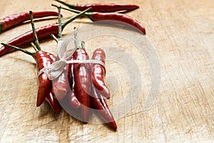 Many red peppers tied on wood table