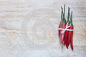 Many red peppers tied on wood table