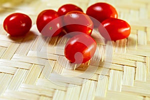 Many red ripe and juicy cherry tomatoes close-up on a wooden background