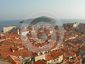 Many red roofs with the sea and an island in the horizon photo