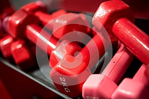 Many red rubberized dumbbells of 2 kg each in the gym photo