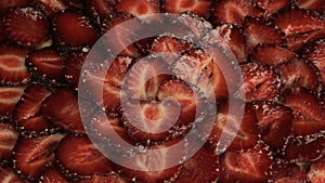 Many red slices of fresh strawberries, rapidly rotates counterclockwise