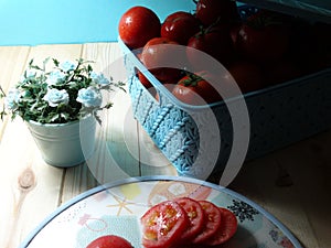 Many red tomato box, blue background, cyan rose, tomato slices