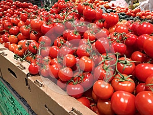 Many red tomatoes in the boxes supermarket