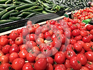 Many red tomatoes and cucumbers in supermarket