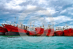 Many red vessels moored in the port of Puerto Deseado, Argentina