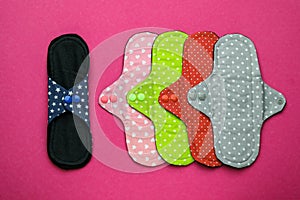 Many reusable cloth menstrual pads on pink background, flat lay