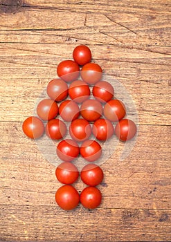 Many ripe red tomatoes lies on wooden surface