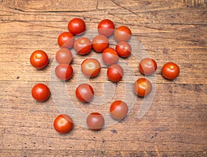 Many ripe red tomatoes lies on wooden surface