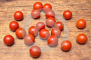 Many ripe red tomatoes lies on wooden surface
