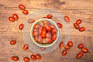 Many ripe red tomatoes lies on wooden surface