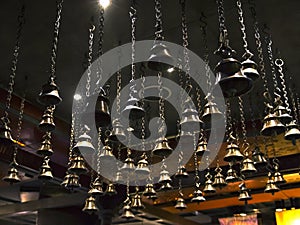 Many ritual bells hanging on chains from the ceiling