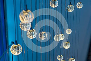 Many round glowing lamps hanging on a blue background