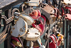 Many rusty love locks hanging on some bridge, closeup. Long term relationship symbol